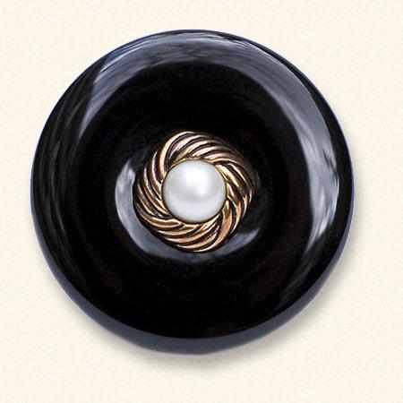 Un bouton de deuil en onyx sur lequel figure le bouton classique d'un être cher. L'onyx noir est toujours uniformément coloré.